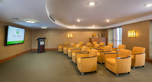 A well-designed conference room featuring bright yellow seating and a podium, ready for presentations or meetings.