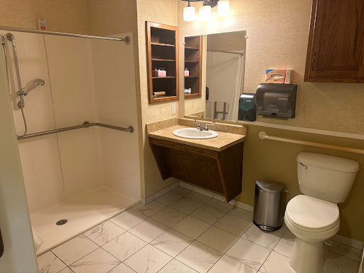 A clean and simple bathroom featuring a shower, toilet, sink, and storage.