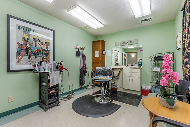 A well-equipped hair salon with a barber chair and a mirror.