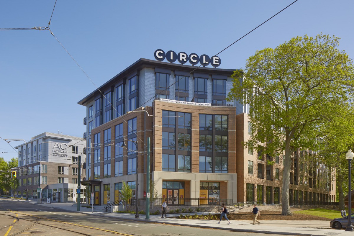 A modern office building with a 'Circle' sign on top, located in an urban area.