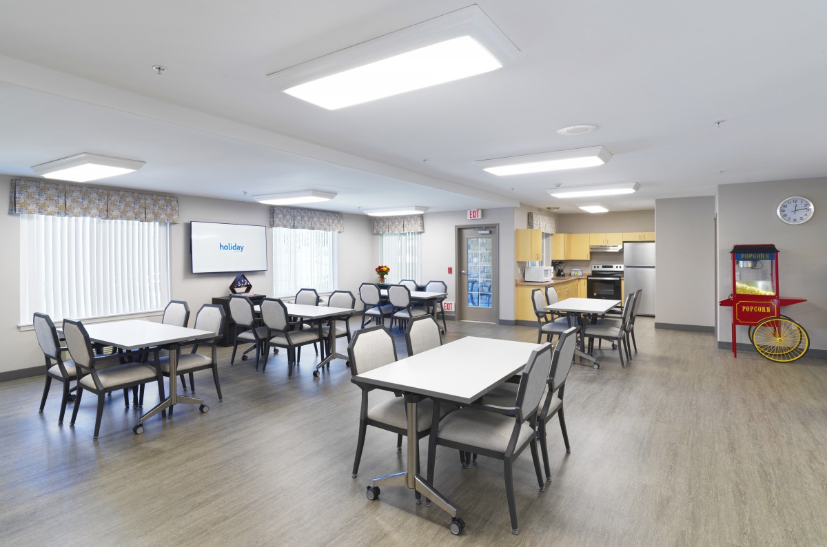 A spacious dining and kitchen area with modern furnishings and large windows.