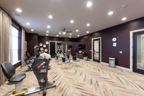 A modern indoor gym with exercise equipment and stationary bikes.