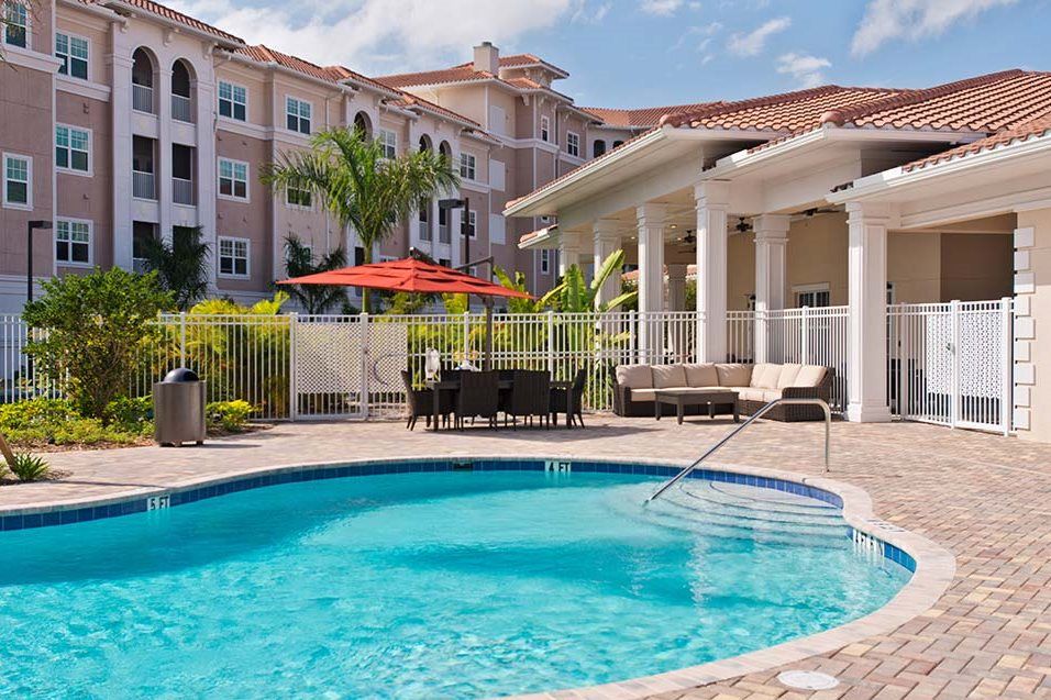 A luxurious resort featuring a refreshing outdoor pool with nearby seating and umbrellas.