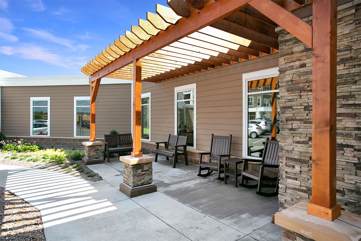 A cozy outdoor patio featuring a wooden pergola and comfortable seating.