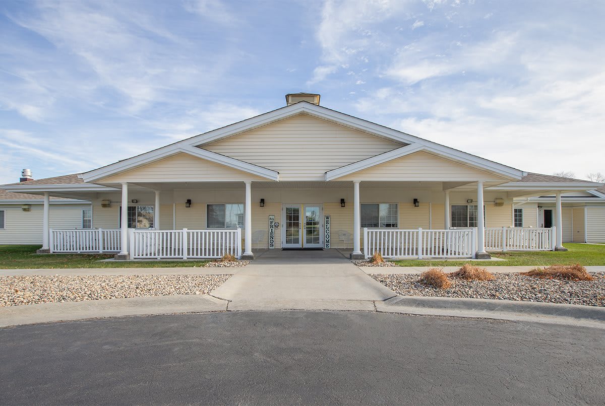 A single-story residential building with a porch and front yard.