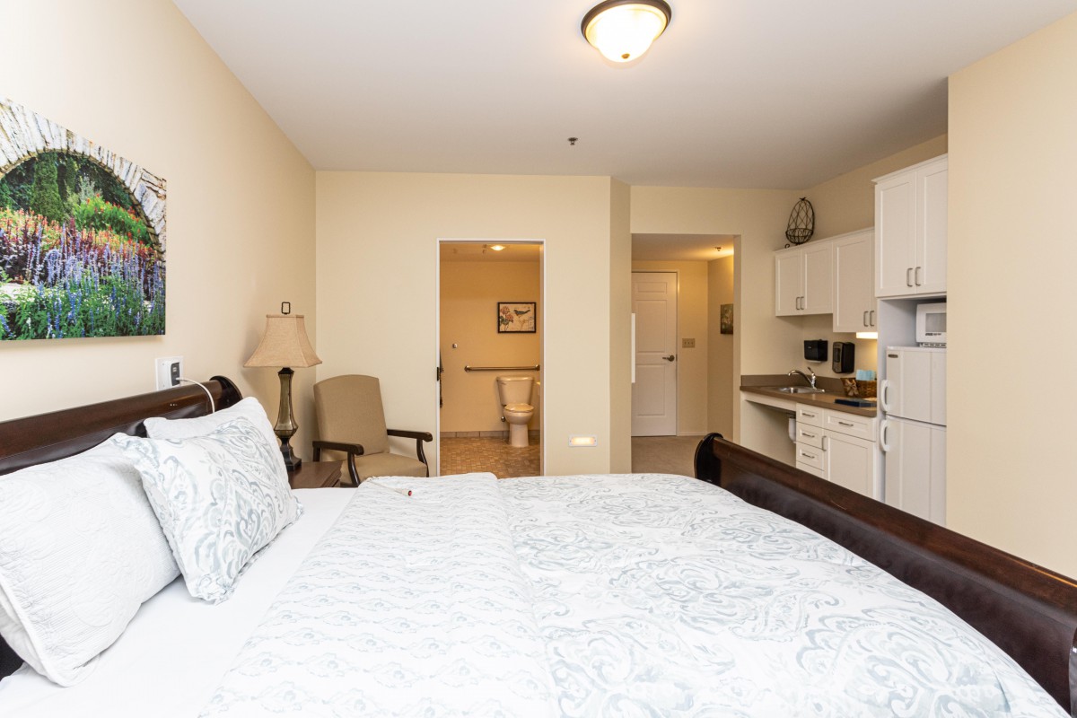 A cozy bedroom with a kitchenette and comfortable furnishings.