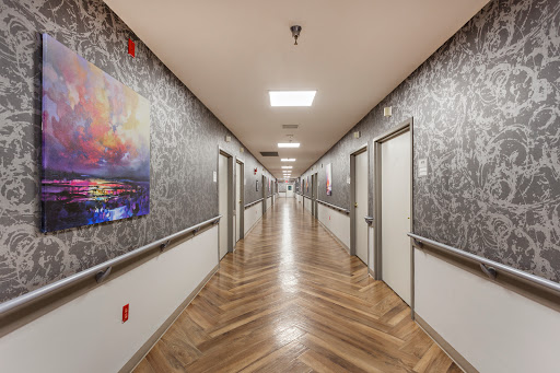 A modern hallway featuring decorative artwork, wooden flooring, and a series of doors.