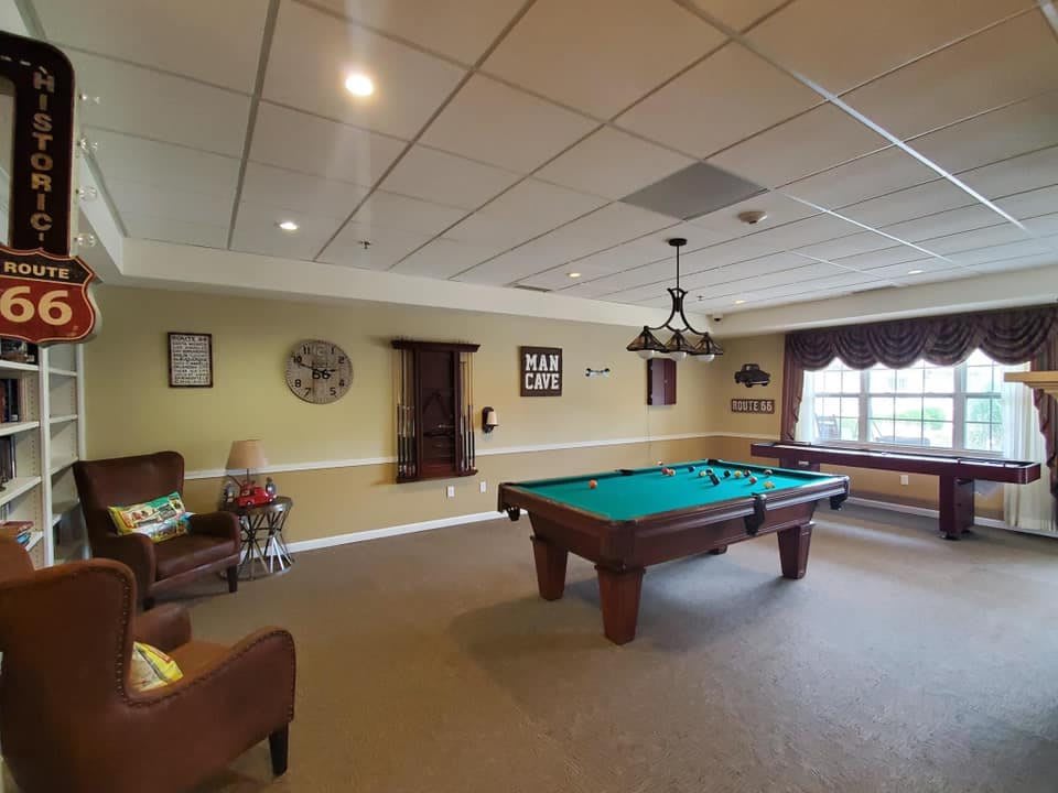 A cozy indoor game room featuring a pool table and seating area.