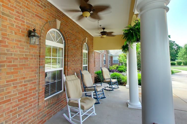A cozy porch with rocking chairs and ceiling fans, perfect for relaxation.