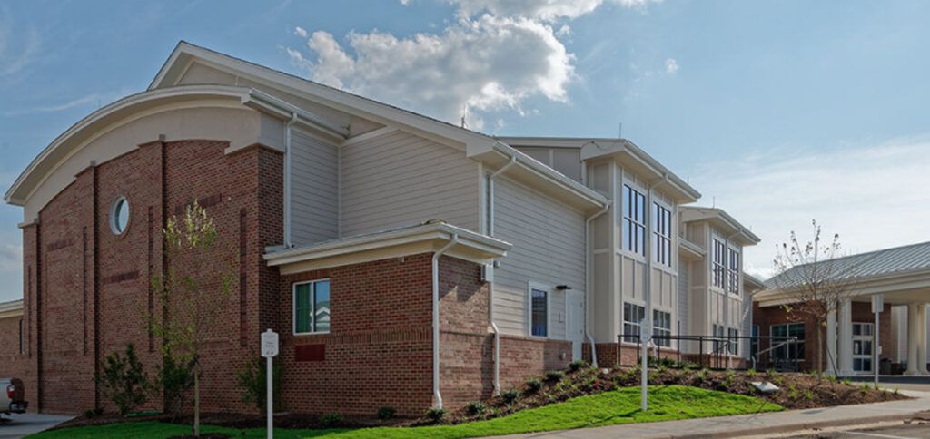 A modern building with a mix of brick and siding under a partly cloudy sky.