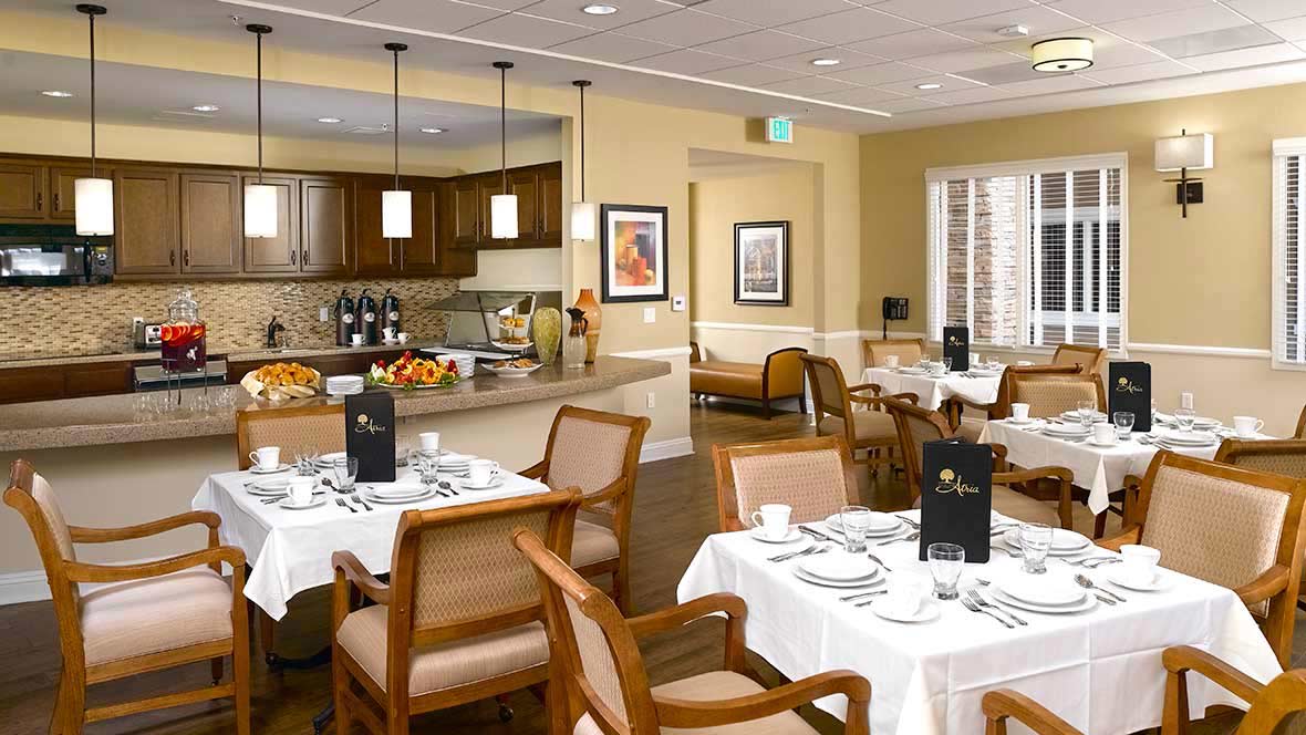 An elegantly arranged dining room with well-set tables and comfortable seating.
