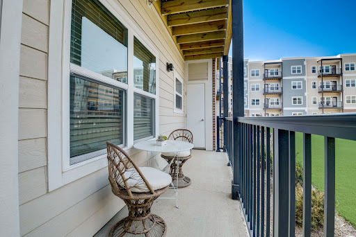 A cozy balcony featuring two chairs, perfect for enjoying a cup of coffee in the morning.
