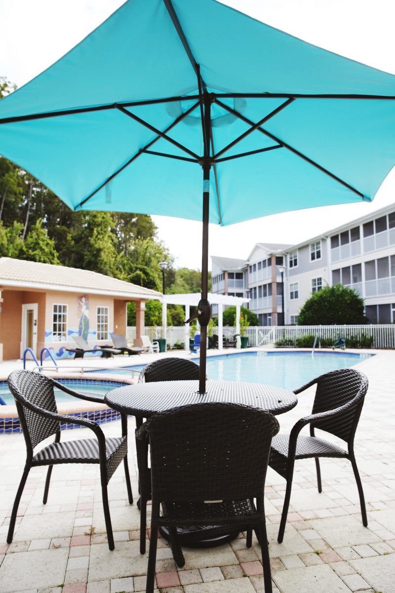 An inviting outdoor pool area with patio furniture and a large umbrella.