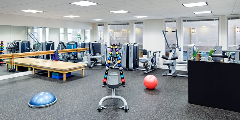 A well-equipped gym with various exercise machines and weights.