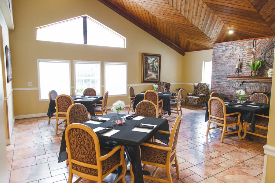 A cozy restaurant dining area with wooden ceilings and neatly arranged tables.
