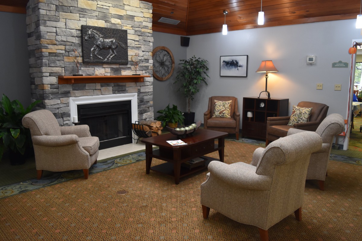 A cozy living room with a stone fireplace and comfortable seating.