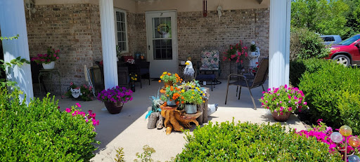 A cozy and vibrant porch filled with colorful flowers and a welcoming seating area.