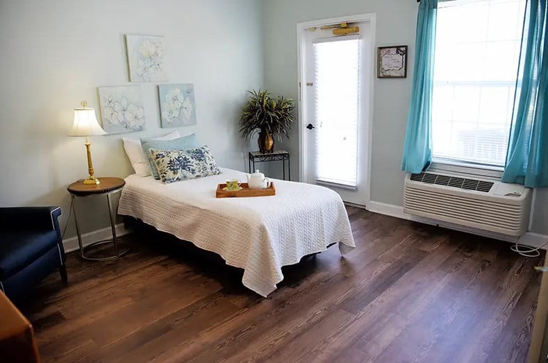 A cozy bedroom with a single bed, minimal decor, and plenty of natural light.