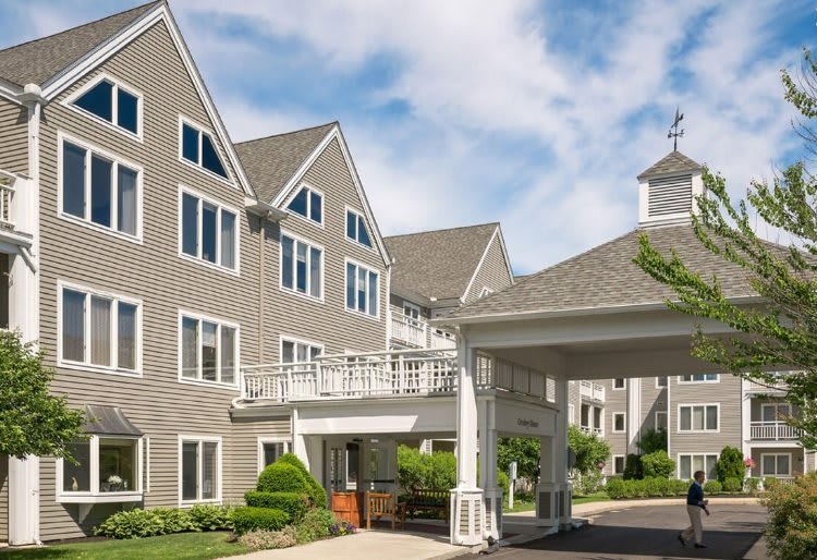 A residential building with a covered entrance and a clear blue sky.