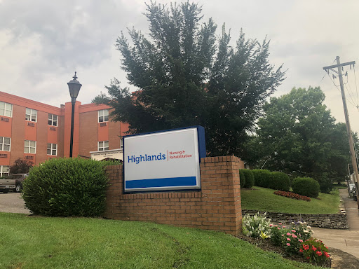A sign for Highlands, surrounded by lush greenery and residential buildings.