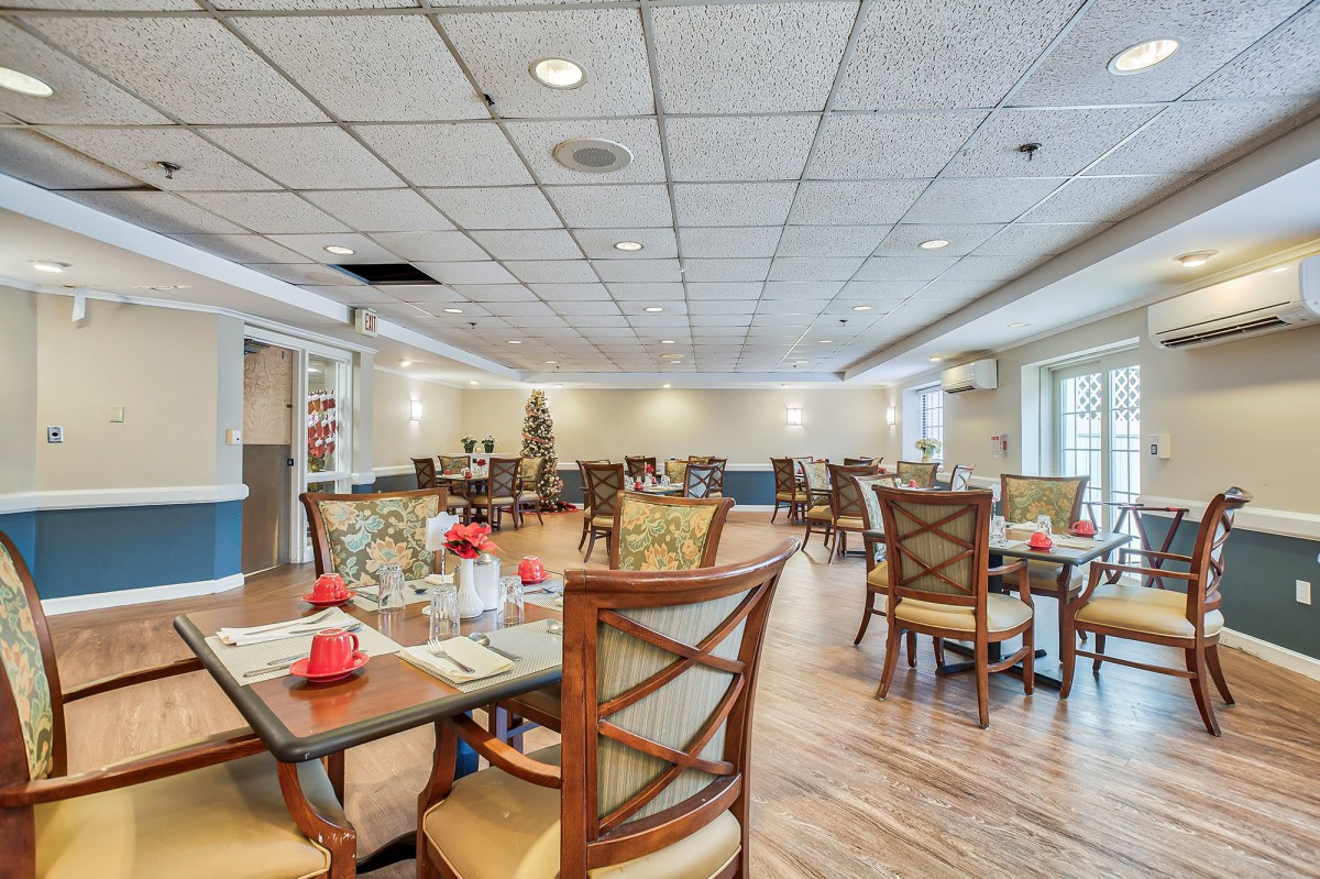 A spacious and well-lit dining area featuring elegantly arranged tables and chairs.