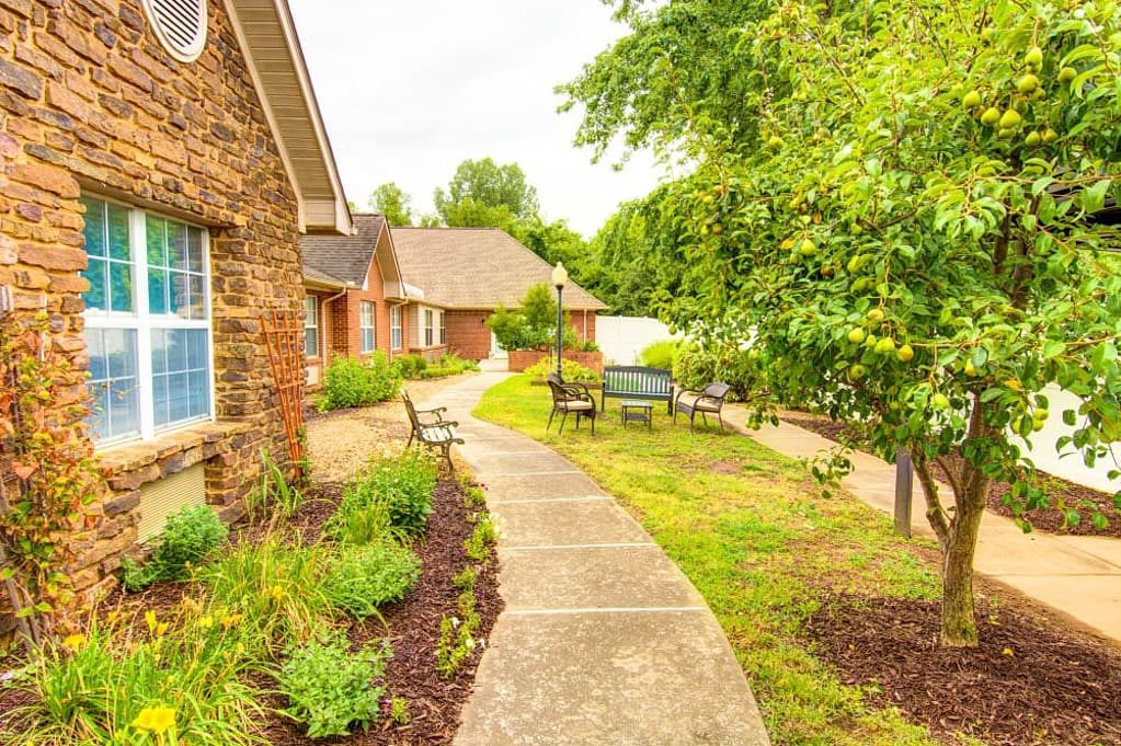 A scenic walkway surrounded by lush greenery and residential houses.