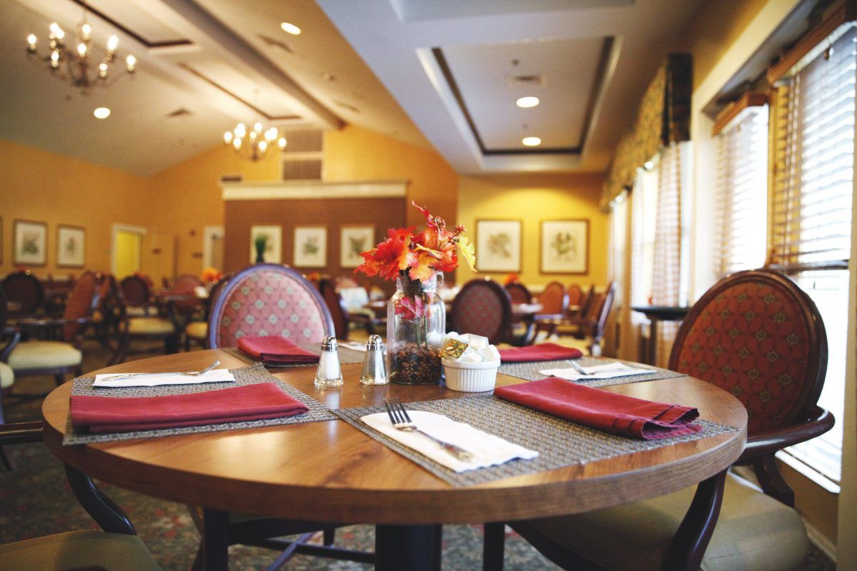 A cozy restaurant interior with neatly set tables and warm lighting.