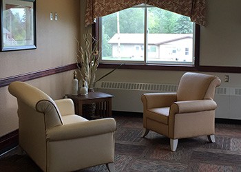A cozy living room with two armchairs positioned near a window.