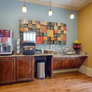 A modern self-service breakfast area with a coffee and beverage station.