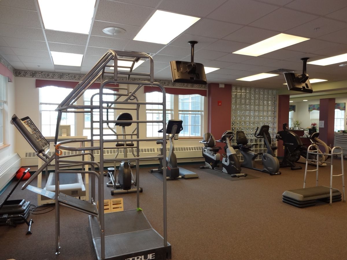 An empty gym with various exercise equipment including treadmills and stationary bikes.