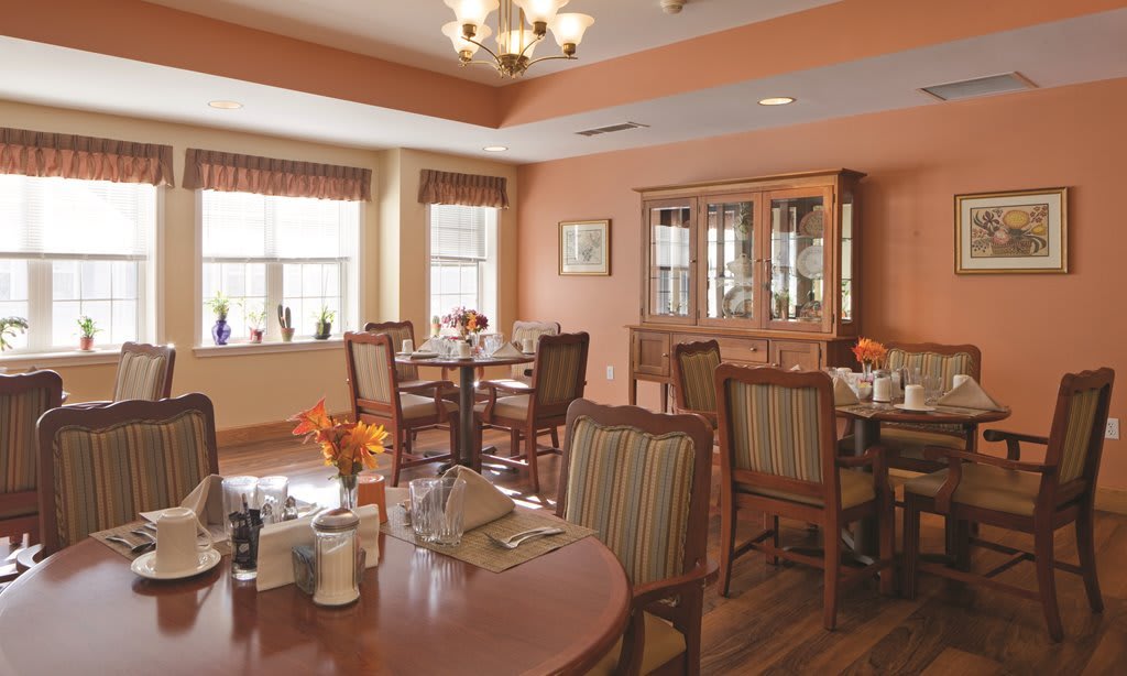 A cozy dining area with neatly set tables and comfortable seating.