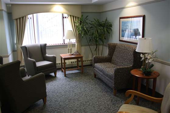A cozy living room area with a sofa, armchairs, and coffee tables.