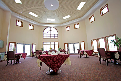A spacious and elegantly designed restaurant interior, featuring tables adorned with tablecloths and abundant natural light.