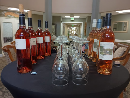 A display of ros wine bottles and glasses, ready for a gathering.