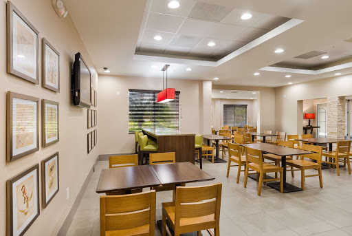 A modern dining area featuring wooden tables and chairs, with bright lighting and a cozy atmosphere.