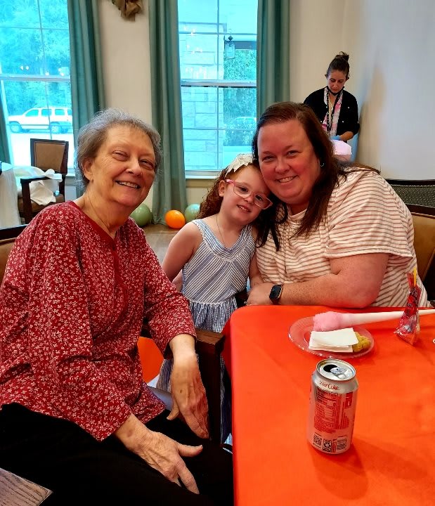 A joyful moment at a family gathering with two women and a child.