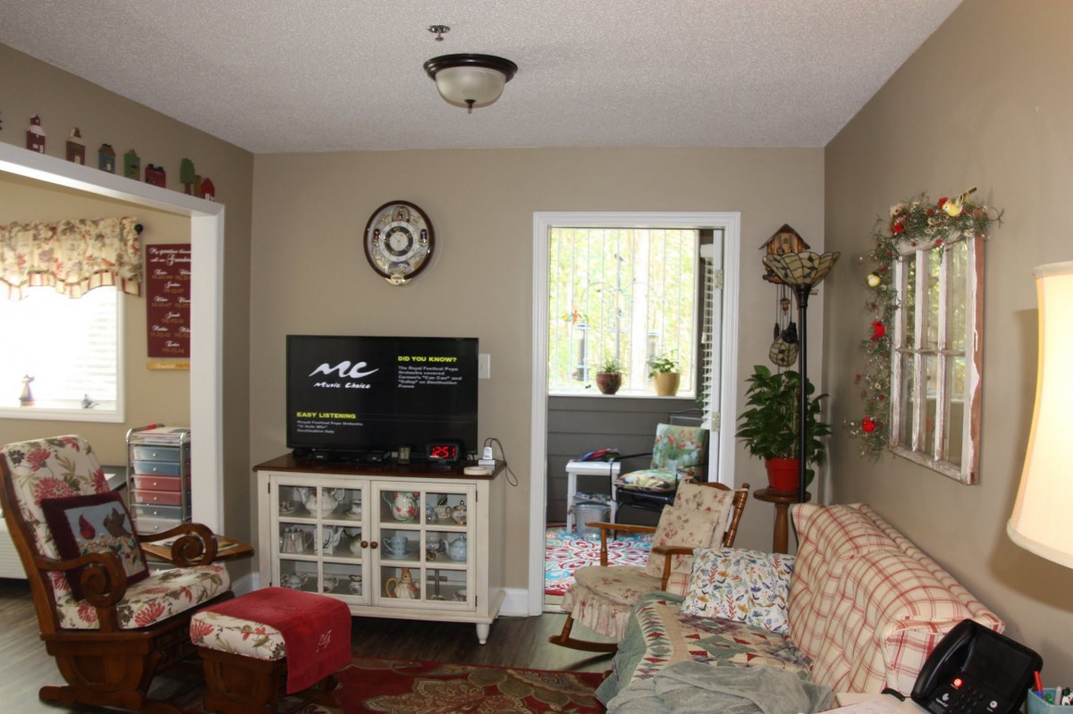 A cozy living room with a TV, comfortable seating, and home decor.