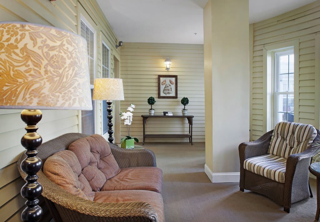 A cozy living room with comfortable seating, a floor lamp, and a decorative table.