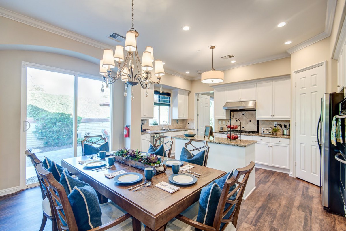 A modern open-concept kitchen and dining area with elegant decor and a stylish chandelier.
