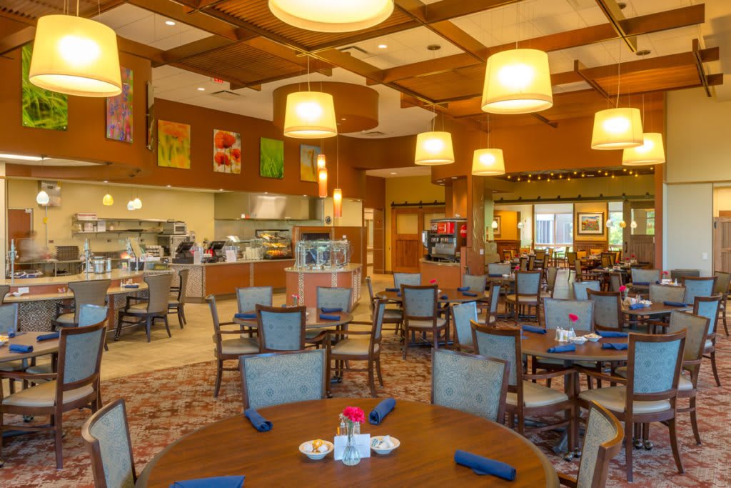 A cozy restaurant interior with tables and chairs, warm lighting, and a welcoming atmosphere.