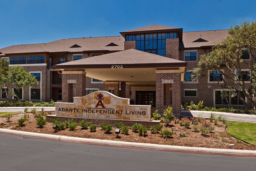 Front view of a senior living facility with landscaped entrance.