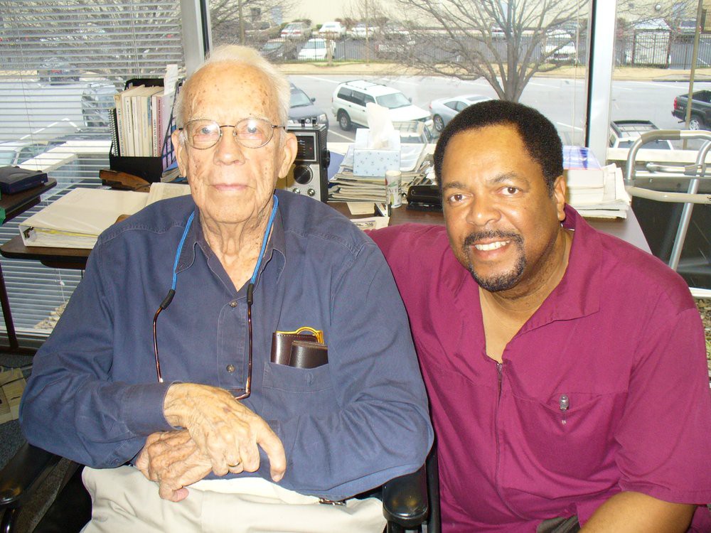 Two men sitting together in an office setting.