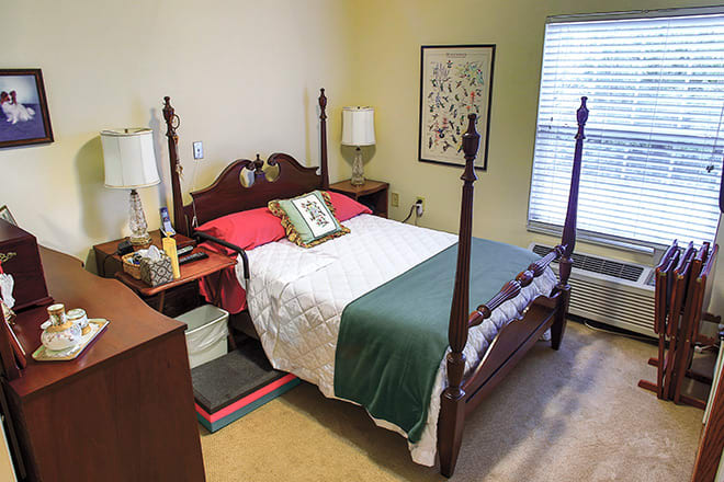 A cozy bedroom with a four-poster bed, bedside tables, and decorative elements.