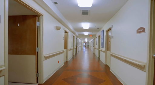 A bright and spacious hospital hallway, featuring doors on either side.