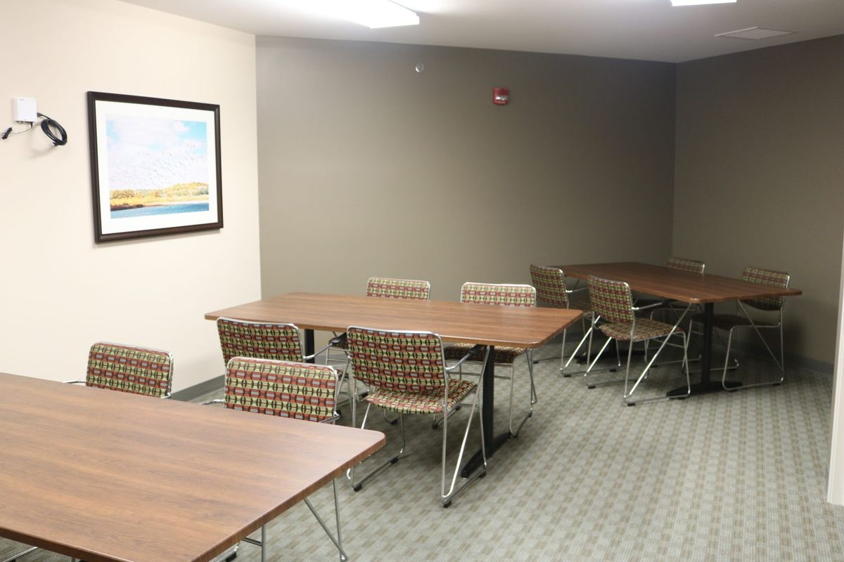 A small conference room with tables and chairs set up for a meeting.