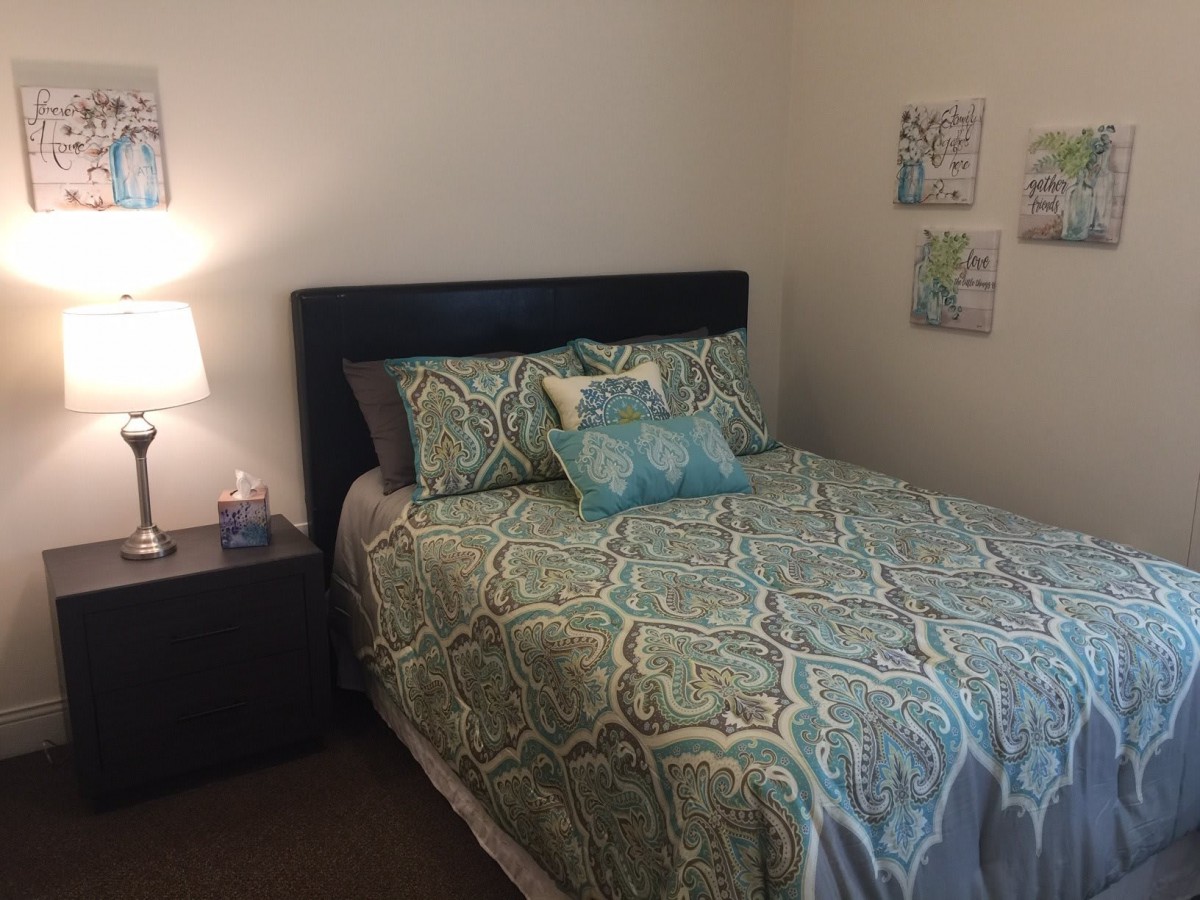 A cozy bedroom with a neatly made bed and stylish decor.