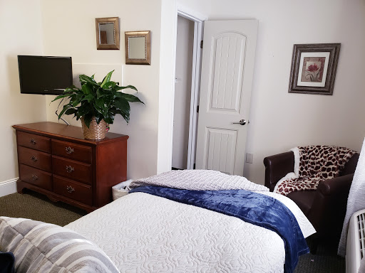 A cozy and inviting bedroom featuring a neatly made bed, a wooden dresser, and decorative elements.