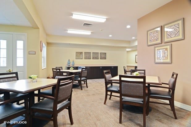 A well-lit dining area with neatly arranged tables and chairs, featuring modern decor and a cozy atmosphere.