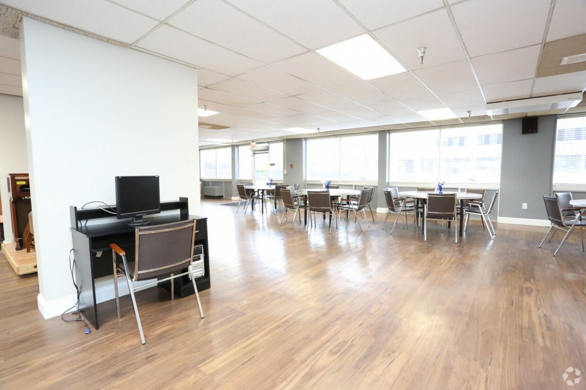 A spacious and bright office area with various workstations and tables.