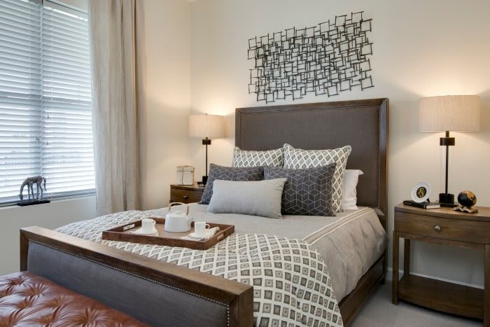 A modern bedroom with stylish bedding and decorative artwork.